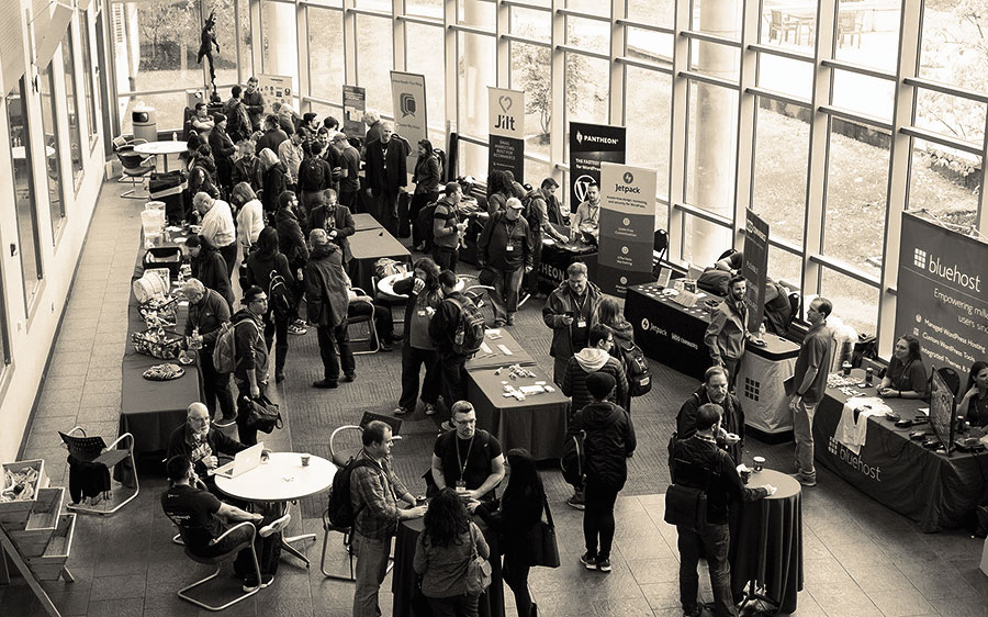 Attendees, seen from above, talk in the atrium WordCamp Philly 2018 at the University of the Sciences