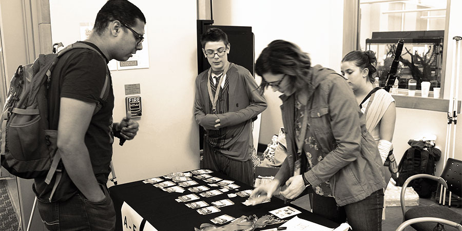 volunteers help an attendee find their name badge at the registration table at WordCamp Philly 2017